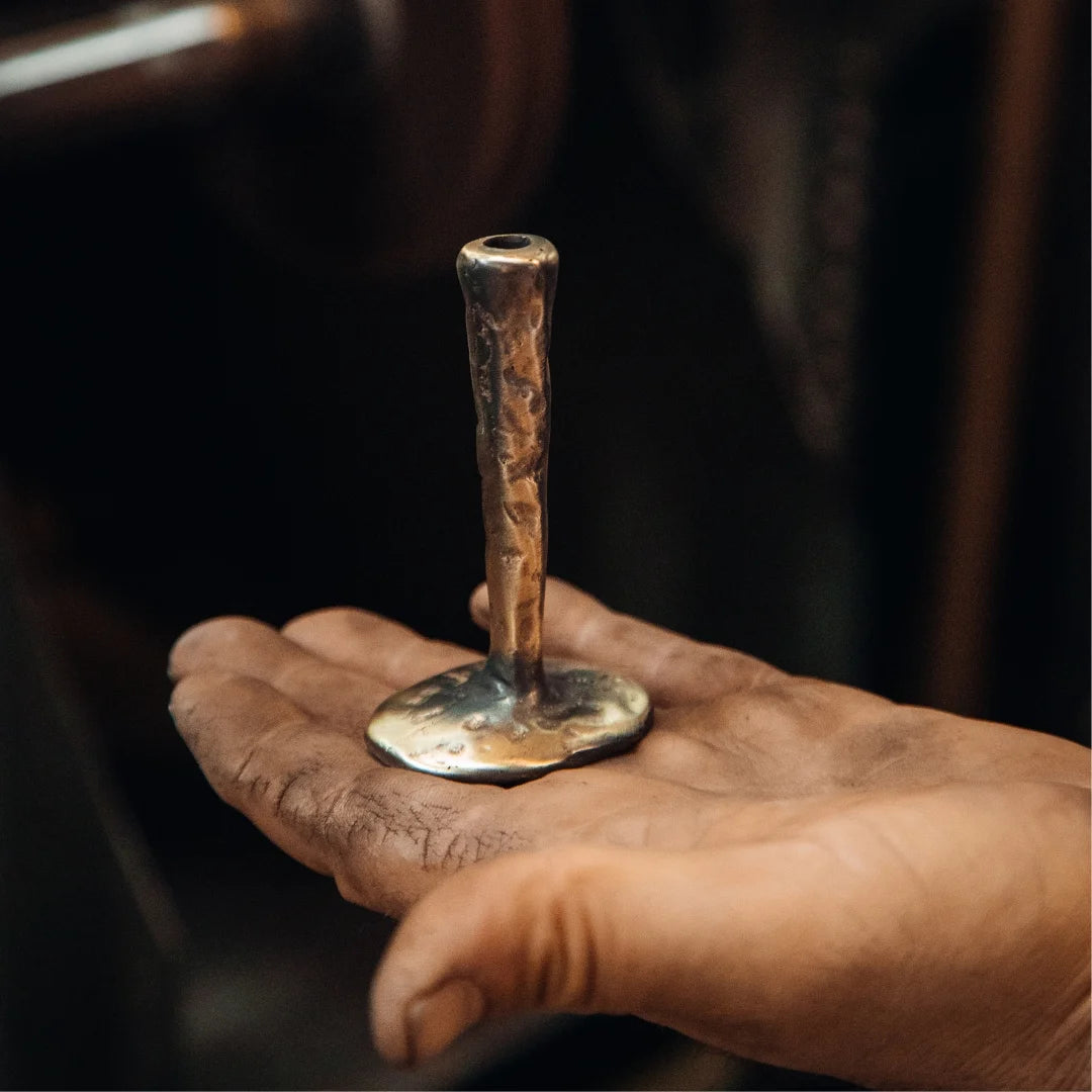 A brass candlestick shaped by hand